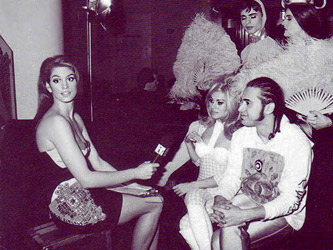Супермоделът Синди Крофорд като моден репортер за MTV, облечена в стил “Джани Версаче”, средата на 90-те години на ХХ век